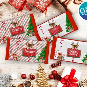 May include: Four rectangular Christmas-themed candy bar wrappers with red and white striped patterns, featuring a reindeer holding a sign. Two wrappers say "Eleanor" and two say "Merry Christmas" or "Feliz Navidad". The wrappers have red edges and Christmas tree graphics.