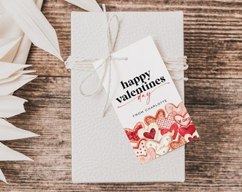 May include: A white gift box with a brown twine bow and a gift tag that reads "happy valentines day from charlotte" with a watercolor illustration of red and pink hearts.