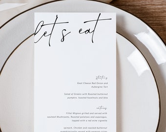 May include: A white menu card with black calligraphy that reads "Let's Eat" and lists a three-course meal: Goat Cheese, Red Onion and  Aubergine Tart, Fillet Mignon and a dessert option of White Chocolate Mousse.