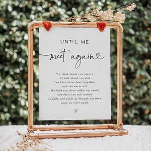 May include: A white sign with a copper pipe frame, displaying the text "UNTIL WE meet again" with a heart symbol. The sign has a message about remembering someone and holding them close in your heart.