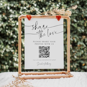Pode incluir: Um cartaz branco com texto preto que diz "share the love" e um código QR. O texto abaixo do código QR diz "Por favor, compartilhe suas fotos conosco. Digitalize com seu smartphone e faça o upload. Sarah & Anthony."