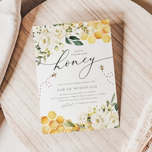 May include: A white and yellow floral bridal shower invitation with a honeycomb pattern and the text "She's found her honey". The invitation includes the bride's name, the date, time, and location of the shower.
