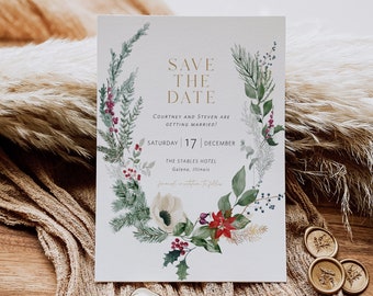 Könnte beinhalten: Save-the-Date-Karte mit einer Aquarell-Illustration eines winterlichen Blumenkranzes in Grün-, Rot- und Weißtönen. Der Text lautet "Save the Date, Courtney und Steven heiraten! Samstag, 17. Dezember, The Stables Hotel, Galena, Illinois."