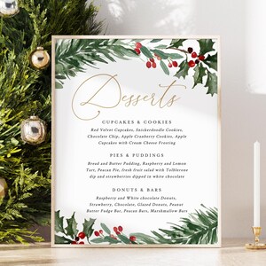May include: A framed dessert menu with a gold border, featuring a watercolor design of green leaves and red berries. The menu lists cupcakes, cookies, pies, puddings, donuts, and bars. A green wreath and gold ornaments are in the background.