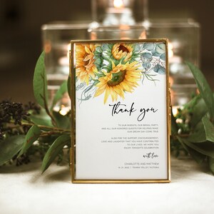 May include: A thank you card with a watercolor illustration of sunflowers and eucalyptus leaves. The card reads "Thank you" and includes a message of gratitude to guests for their support. The card is signed "Charlotte and Matthew" and includes the date "10.21.2022" and location "Yearra Valley, Victoria".