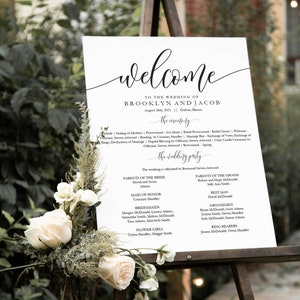 Peut inclure: Une pancarte de cérémonie de mariage blanche avec du texte noir. La pancarte comprend les noms Brooklyn et Jacob, la date du 28 août 2021 et le lieu Galena, Illinois. La pancarte liste également les membres de la fête de mariage, y compris les parents de la mariée et du marié, la demoiselle d'honneur, les demoiselles d'honneur, les demoiselles d'honneur, le témoin, les garçons d'honneur et les porteurs d'alliances.