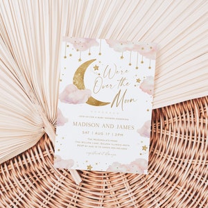 May include: A baby shower invitation with a celestial theme. The design features a gold crescent moon and stars, with the text "We're Over the Moon." Pink clouds and gold stars decorate the edges. The invitation is on a white background.