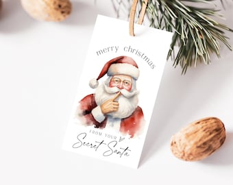 May include: A white gift tag with a watercolor illustration of Santa Claus with a red hat and beard. The text on the tag reads "merry christmas from your Secret Santa".