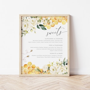May include: A printable sign featuring a watercolour floral design and a honeycomb pattern. The sign reads "sweets" and lists a variety of desserts, including cupcakes, cookies, pies, puddings, doughnuts, and bars.