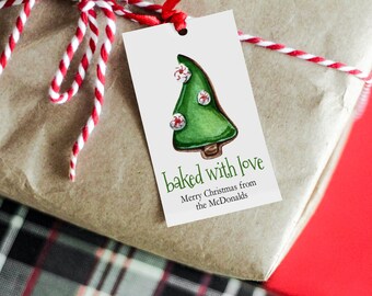 May include: A white gift tag with a green gingerbread Christmas tree decorated with red and white candy canes. The tag reads "baked with love Merry Christmas from the McDonalds".