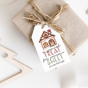 Op de afbeelding: Een wit cadeau-etiket met een illustratie van een peperkoekhuis en de tekst "een speciaal cadeau voor iemand die lief is van de McDonalds".