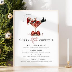 May include: A framed print with a Christmas cocktail theme. The image features a martini glass with Santa Claus relaxing inside. Text includes "Merry Little Cocktail" and cocktail recipes like "Mistletoe Mojito".