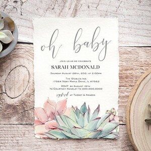 May include: Baby shower invitation with the words "oh baby" in elegant script. The invitation includes event details and watercolor succulents in shades of pink and green. The invitation is on textured paper.