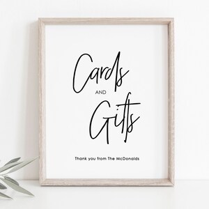 May include: A white framed sign with black calligraphy that reads "Cards and Gifts" with the text "Thank you from The McDonalds" below.