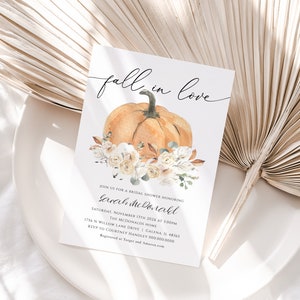 Op de afbeelding: Een bruidsdouche-uitnodiging met het thema "Verliefd op de herfst" met een aquarelillustratie van een pompoen en witte bloemen. De uitnodiging bevat de datum, tijd en locatie van het evenement. RSVP naar Courtney Handley op 000.000.0000.
