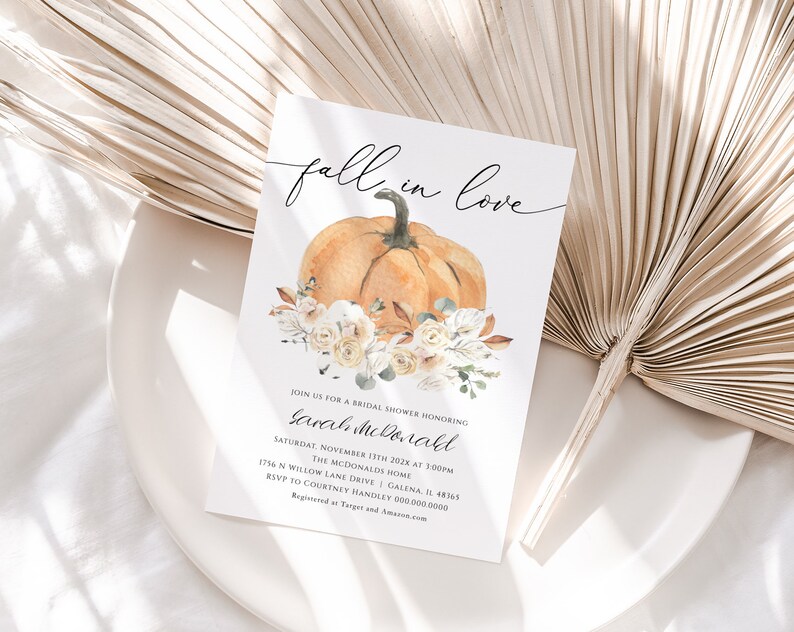 Op de afbeelding: Een bruidsdouche-uitnodiging met het thema "Verliefd op de herfst" met een aquarelillustratie van een pompoen en witte bloemen. De uitnodiging bevat de datum, tijd en locatie van het evenement. RSVP naar Courtney Handley op 000.000.0000.