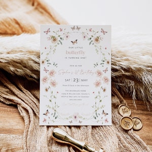 Könnte beinhalten: Eine Geburtstagseinladung mit dem Text "OUR LITTLE butterfly IS TURNING ONE!", umgeben von einem Blumen- und Schmetterlingsdesign. Die Einladung enthält den Namen "Sophia's 1st Birthday" und das Datum "SAT 23 MAY". Ein goldener Wachssiegel und Stempel sind ebenfalls sichtbar.