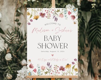 May include: A white welcome sign with floral border and the text "WELCOME TO Madison + Joshuas BABY SHOWER Saturday, August 12, 202x 45 Days until Baby is Due!"