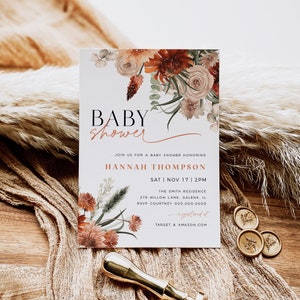 May include: A baby shower invitation with a floral design in shades of orange, pink, and green. The text reads "Baby Shower" and includes the name "Hannah Thompson", the date "Sat | Nov 17 | 2PM", the location "The Smith Residence", and the address "276 Willow Lane, Galena, IL".