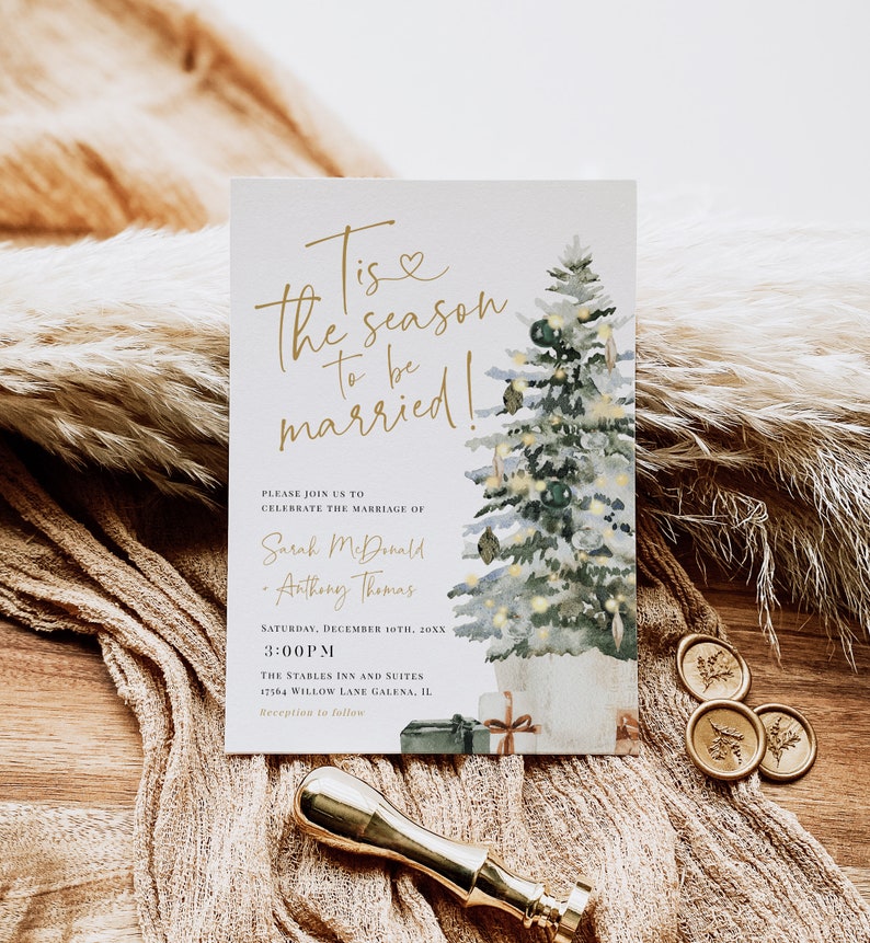 May include: A watercolor illustration of a Christmas tree with lights and ornaments. The text "Tis the season to be married!" is written in gold script. The invitation is for a wedding on December 10th at 3:00 PM at The Stables Inn and Suites in Galena, Illinois.