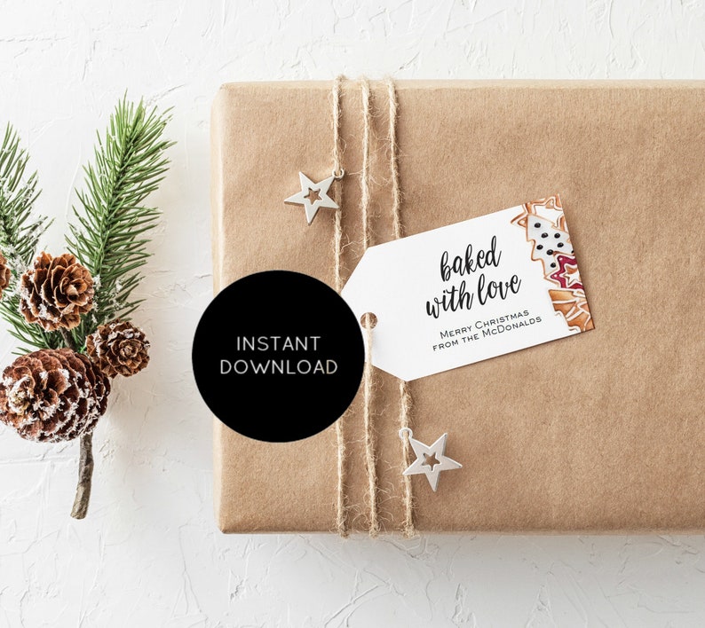 May include: A white gift tag with the text "baked with love" and "Merry Christmas from the McDonalds" printed on it. The tag is tied with twine to a brown paper gift box with a star-shaped ornament.
