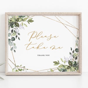 May include: A framed sign with the text "Please take one" in gold script. The sign is decorated with watercolor greenery and gold geometric accents. The frame is a light wood color, and the overall design is elegant and suitable for weddings or events.