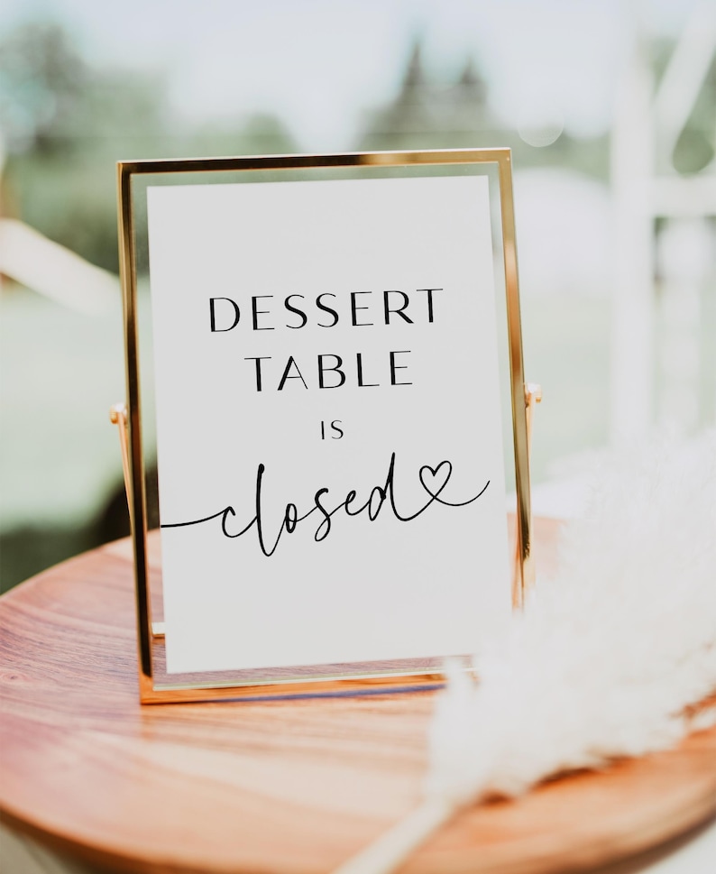 May include: A gold-framed sign with the text "Dessert Table is closed" with a small heart symbol.