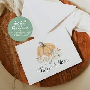 Puede incluir: Una tarjeta de agradecimiento imprimible con una ilustraci&oacute;n de acuarela de una calabaza con flores blancas y vegetaci&oacute;n. El texto "Gracias" est&aacute; escrito en cursiva debajo de la calabaza.