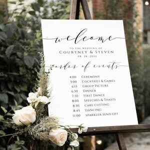 May include: A white wedding welcome sign with black calligraphy text. The sign lists the order of events for the wedding of Courtney and Steven on August 28, 2022. The sign is on an easel.