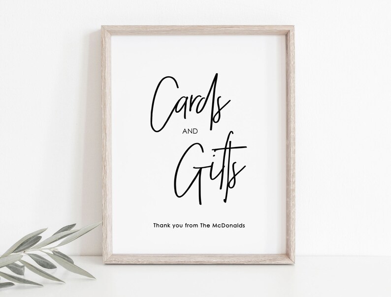 May include: A white framed sign with black calligraphy that reads "Cards and Gifts" with the text "Thank you from The McDonalds" below.