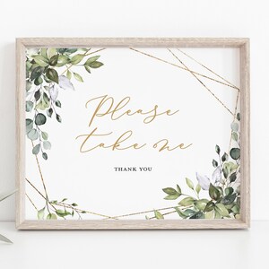 May include: A framed sign with the text "Please take one" in gold script. The sign is decorated with watercolor greenery and gold geometric accents. The frame is a light wood color, and the overall design is elegant and suitable for weddings or events.