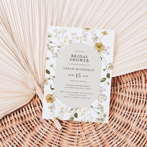 May include: A white floral bridal shower invitation with a light gray circle in the center. The text reads "Join us for a Bridal Shower in celebration of marriage for Sarah McDonald Sun 15 Aug The McDonald Residence 123 N Willow Lane, Gotham, Illinois RSVP by August 1st with your name and number at [email protected] or register at Target & Amazon.com"