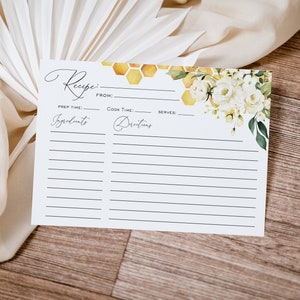 May include: A white recipe card with a floral design featuring white roses and green leaves. The card has a honeycomb pattern and the words "Recipe" and "From:" at the top. The card has sections for "Prep Time", "Cook Time", "Serves", "Ingredients", and "Directions".