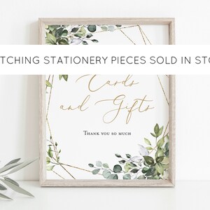 May include: A framed sign with the words "Cards and Gifts" in gold script. The sign is decorated with green and white botanical elements and gold geometric accents. The text "Thank you so much" is at the bottom.