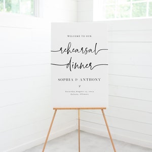 May include: White sign with black text announcing a rehearsal dinner for Sophia and Anthony. The event is scheduled for Saturday, August 11th in Galena, Illinois.