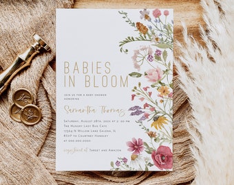 May include: A white baby shower invitation with a floral design. The text reads "Babies in Bloom" and "Samantha Thomas". The invitation includes the date, time, location, and RSVP information.
