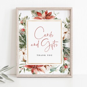 May include: A printable sign with a watercolor floral design featuring red poinsettias, green pine branches, and white cotton bolls. The sign says "Cards and Gifts" with the text "Thank You" below.