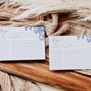 May include: Two blank recipe cards with a blue floral design. The cards have spaces for the recipe name, ingredients, directions, cook time, and servings.