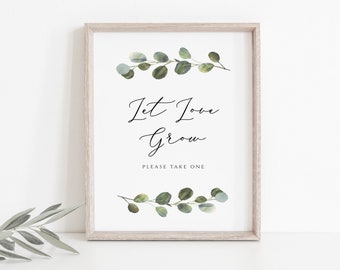 May include: A framed sign with a watercolor illustration of eucalyptus leaves. The sign says "Let Love Grow" and "Please Take One".
