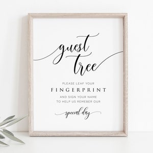 Könnte beinhalten: Ein weiß gerahmtes Schild mit schwarzem Text, auf dem "guest tree" steht. Der Text darunter lautet: "Bitte hinterlassen Sie Ihren Fingerabdruck und unterschreiben Sie Ihren Namen, um uns zu helfen, unseren besonderen Tag in Erinnerung zu behalten."
