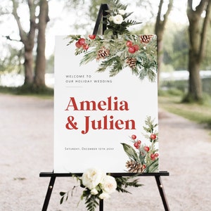 Puede incluir: Un cartel de boda blanco con un diseño de acuarela de ramas de pino, piñas y bayas rojas. El cartel dice "Bienvenido a nuestra boda navideña Amelia & Julien Sábado, 10 de diciembre de 20XX".