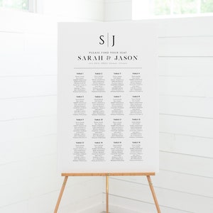K&ouml;nnte beinhalten: Ein wei&szlig;er Hochzeitssitzplan mit schwarzem Text. Der Plan listet die Tische mit den Namen der G&auml;ste auf, darunter David Adams, Sue Adams, Robert McDonald und Courtney Manley. Der Plan ist mit "Bitte finden Sie Ihren Platz" und "Sarah & Jason" betitelt, mit dem Datum "24. Juli 2022" und dem Ort "Galena, Illinois".