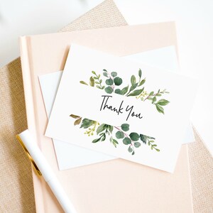 May include: A white card with a green watercolor floral border and the text "Thank You" in black script.