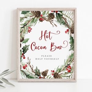 May include: A printable sign with a watercolor wreath of pine branches, holly, and red berries. The sign says "Hot Cocoa Bar" with the text "Please Help Yourself" below.