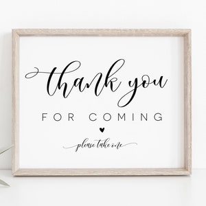 May include: A framed sign with the text "Thank you for coming, please take one" in black calligraphy with a small black heart between the words "for" and "coming".