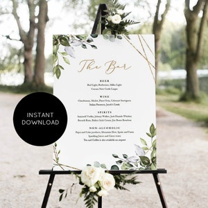 May include: A printable wedding bar sign with a white background and green foliage. The sign lists the drinks available at the bar, including beer, wine, spirits, and non-alcoholic options. The text "The Bar" is written in cursive at the top of the sign.