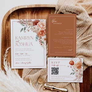 May include: Wedding invitation suite featuring floral arrangements in shades of rust, cream, and green. The invitation includes the names "Kamryn and Joshua" and event details. Additional cards provide reception and RSVP information.