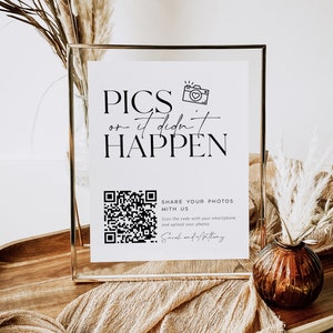 Op de afbeelding: Een wit bord met zwarte tekst die "PICS or it didn't HAPPEN" luidt. Onder de tekst bevindt zich een zwart-witte QR-code met de woorden "SHARE YOUR PHOTOS WITH US" en instructies om de code te scannen met een smartphone en foto's te uploaden. De tekst "Sarah and Anthony" staat onderaan het bord.