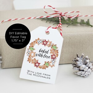 May include: White gift tag with a red and white twine bow. The tag features a wreath of gingerbread cookies with red, green, and white icing. The text "baked with love" is written in black cursive. The text "WITH LOVE FROM THE MCDONALDS" is written in black below the wreath. The tag is 1.75 inches by 3 inches.
