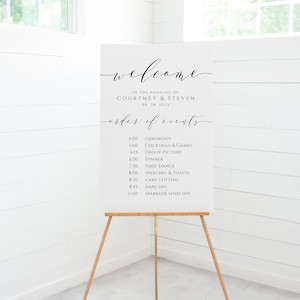 May include: White wedding welcome sign with black calligraphy text. The sign lists the order of events for the wedding of Courtney and Steven on August 28, 2022.